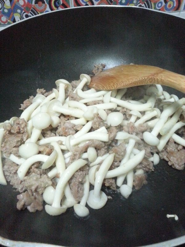 待豬肉8成熟後，加入鮮菇及薑蓉炒拌。