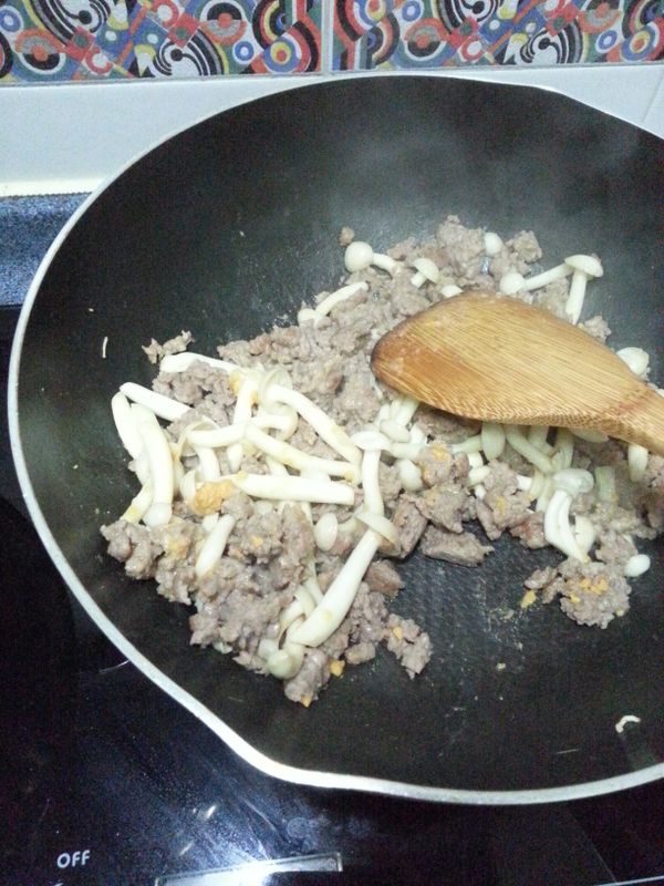 鮮菇炒到8成熟時，加入咸蛋黃碎，繼續炒拌。最後加入1湯匙豉油炒勻。