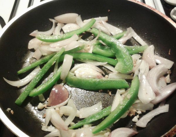 預熱平底鍋，下油用中火煮蒜頭，洋蔥，青/紅椒，煮約4分鐘