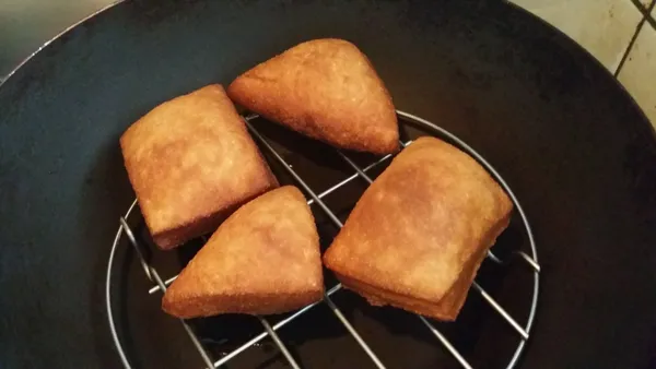 炸好的麵糰可先移至開有小火並放上網架的鍋中瀝油並保溫，再陸續炸完剩餘的麵糰。(30分鐘內可以確保剛炸好的口感)