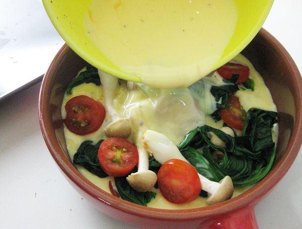 烤盤(可用刷上少許奶油)，放入鴻喜菇、菠菜葉、番茄片。將蛋液倒入步驟3.烤盤中