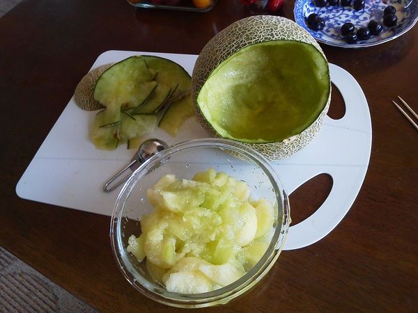 切口處若不平整，可以修切一下（有點弧度）。
然後再把挖出來的果肉的一半放入中間洞裡。
再放入各類圓型的小水果。