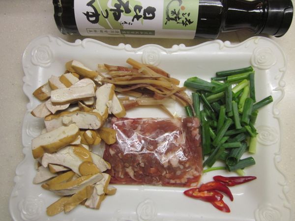備料,將豆干切條.青葱及辣椒切段.大蒜拍碎,乾魷魚剪條狀泡水發漲