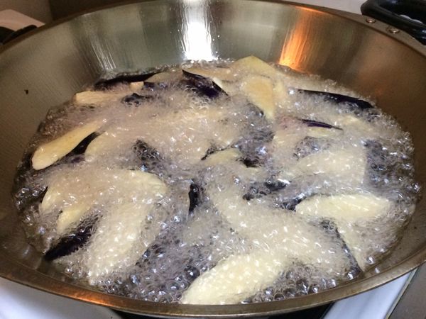 鍋中入油燒熱至約180°c,小心的倒入茄子炸透