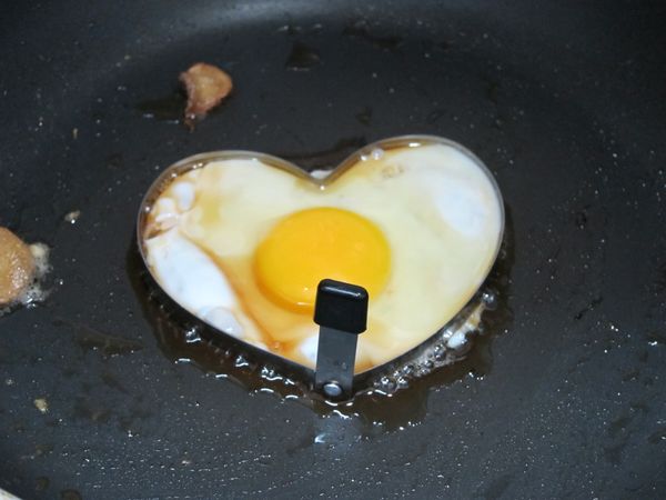 模型內部抹上少油，打上蛋；小火上蓋慢慢煎熟。
