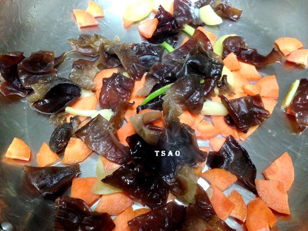 熱鍋加入雞油，開中火爆香薑片、蒜及蔥白，等香氣出來後，再放入紅蘿蔔及黑木耳拌炒約1分鐘。