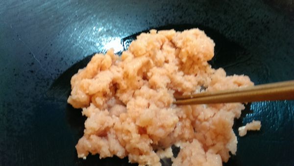 平底鍋熱2大匙油，放入雞絞肉以筷子邊攪拌邊炒鬆。