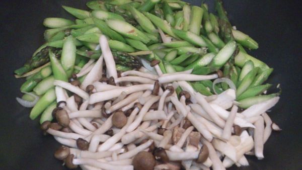 燒熱鍋下油，爆香乾蔥片和蒜蓉，下露荀和雙菇快手炒至乾身