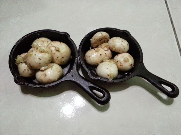 洋菇洗淨，梗切齊(摘掉也可以)，加入醃料混合靜置一段時間(沒時間的也可以不用等直接進烤箱)。
放到烤皿上，我是用3.5吋超迷你Lodge鑄鐵盤來裝。