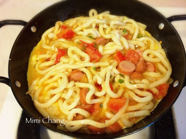 加入麵條，與菜炒勻後，倒入蛋汁。