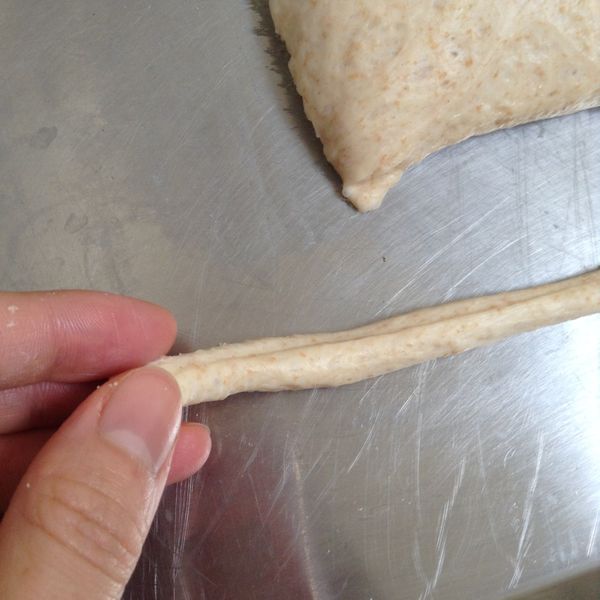 用雙手輕輕拉成適當的長條狀。（每一條都要差不多的粗細，以免細者先烤焦）
