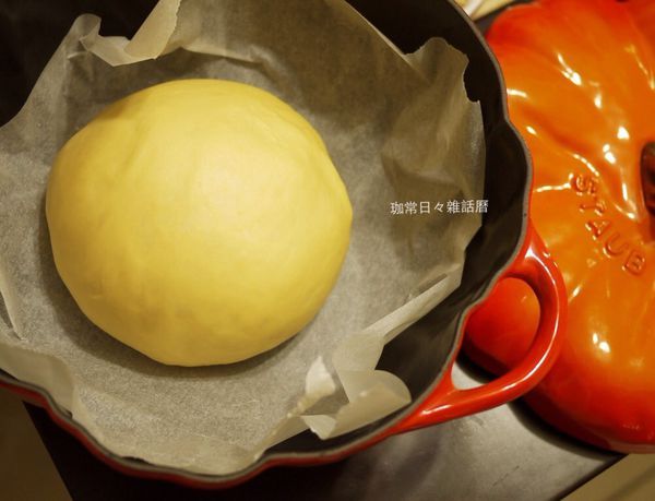 將揉好的麵團滾圓並收口朝下，放入已鋪烘焙紙的鑄鐵鍋 麵團表面噴些許水，蓋上鍋蓋等６０分鐘的第一次發酵,等發酵至約２倍大