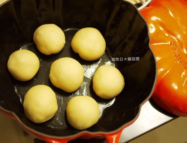 再平均分割成想要的大小,將每份滾圓後，收口朝下，放入鍋內已抹奶油的鑄鐵鍋, 也是表面噴點水，蓋鍋蓋做第二次的發酵(約40-50分鐘)