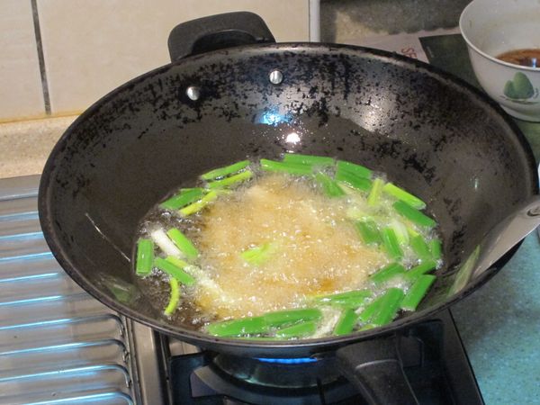 再加入大蒜、青蔥一起，芋頭炸至表面呈現略帶金黃色即可起鍋備用