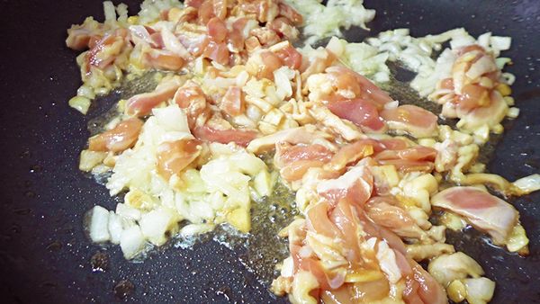 加入些油，加入洋蔥爆香，加入雞腿肉、火腿丁、紅蘿蔔丁炒至熟。