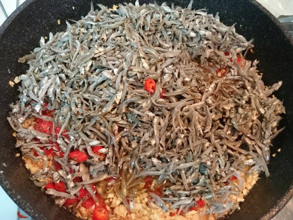 辣椒炒至水份變少後，加入瀝乾的小魚乾，再倒入米酒。