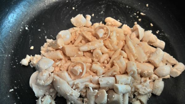 起油鍋將鹹蛋放入鍋中炒到起泡這時倒入燙熟的精靈菇拌炒一下最後放入蔥花完成