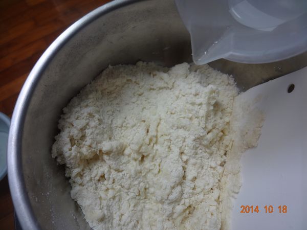 7. 邊加入水邊按壓，只要麵粉能成糰不會散開就停止加水
   (不要用手去按壓，因為手的溫度會加速奶油融化，更不好操作)