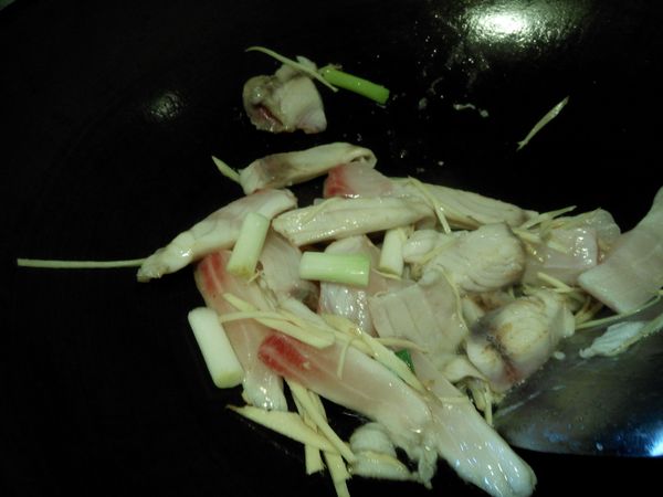 取一熱鍋倒入苦茶油爆香薑絲.蔥段然後加入魚片