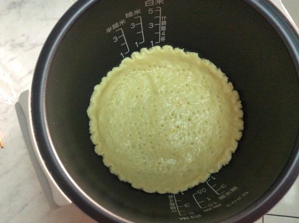 [派皮]上方塑膠袋撕起，連著保鮮膜拿著，平舖在電子鍋內鍋，再用筷子在派皮邊緣往下劃花邊，再用叉子在派皮上戳洞