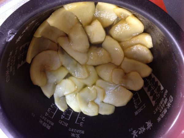 煮好的蘋果，把鍋裡的汁液倒到電子鍋中。
等蘋果稍涼後，把蘋果一片一片排好，最好有點比底部的圓來的向外伸展一點，這樣完成後邊邊會比較漂亮。
再把留在鍋裡的糖液全部倒到電子鍋中。