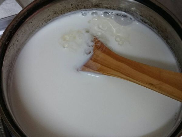 將軟化的吉利丁片擠乾水份後放入煮熱的鮮奶中，攪拌至吉利丁片溶化。