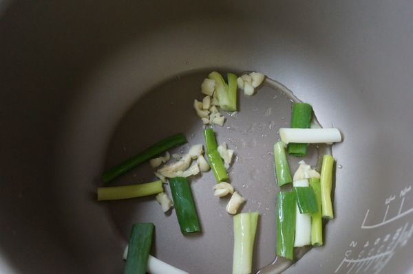 將蒜頭、青蔥放入內鍋中炒香。
