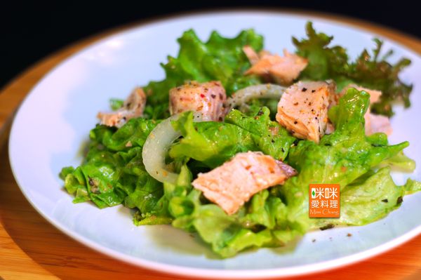 將烤好的鮭魚用手剝成碎片，撒在沙拉上，再撒上七彩胡椒粉，即可上桌。