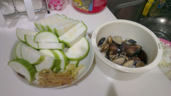 蛤蜊去沙備用；絲瓜削皮，切片狀備用；蒜頭拍碎，薑切絲