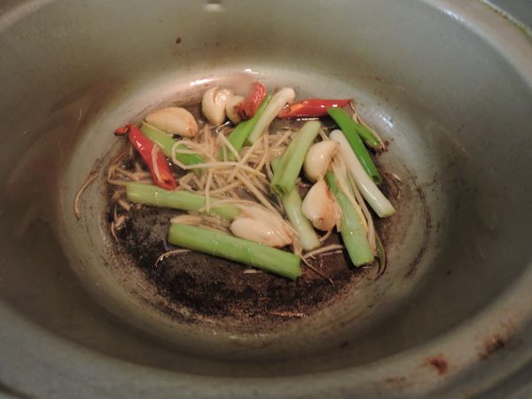 起一油鍋爆炒蒜頭、辣椒、青蔥、薑絲