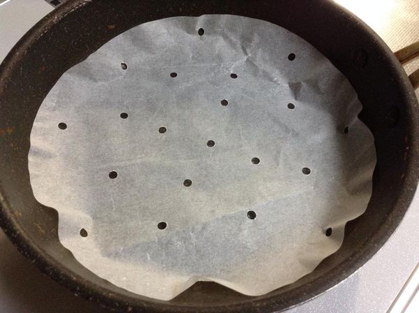 18公分圓鍋上舖好烘焙紙，上面要打洞。（市面上有買好有打洞現成的烘焙紙）