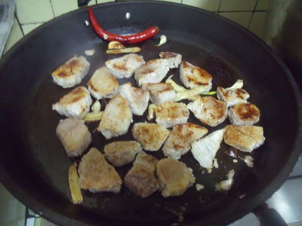 鍋中放一大匙的油,爆香薑片,蒜末,蔥段(用蔥白部份)跟辣椒後,放入切塊的肉,煎至兩面金黃。