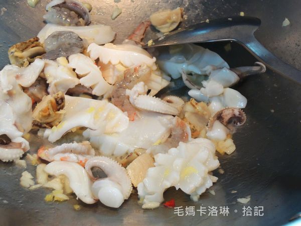 再依序放入花枝、干貝、白蝦快炒後嗆一點米酒