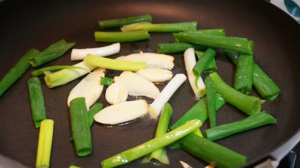 熱鍋熱油後，先放大蒜及薑片爆香，再放入青蔥一起爆香。