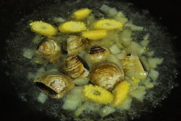 加入2杯水煮滾再加入玉米筍與蛤蜊。