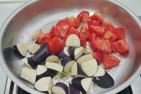 起熱油鍋，放入蔥白、蒜末爆香，再放入蕃茄、茄子翻炒3分鐘。