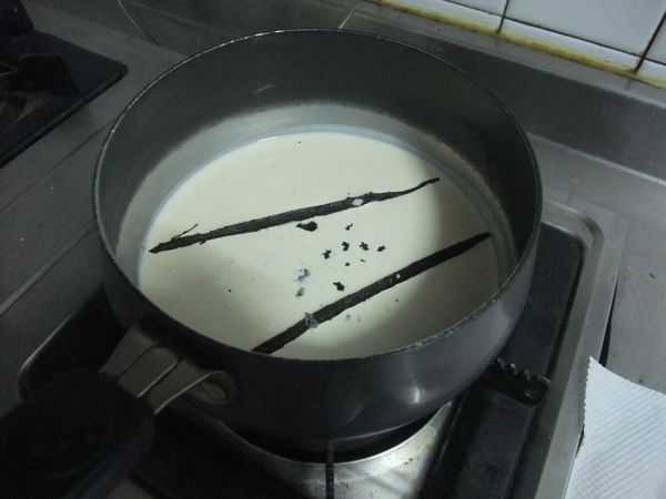 將香草莢剖半後，把香草籽刮出，丟進鮮奶油裡，以小火慢煮至微微溫熱。
★不要煮到滾★