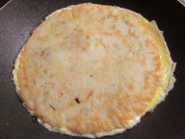 平底鍋熱油舀入[麵糊]攤平,煎到金黃色後先盛起,再將蛋打散入鍋中,趁蛋未凝固將蛋餅平放上面使其黏著