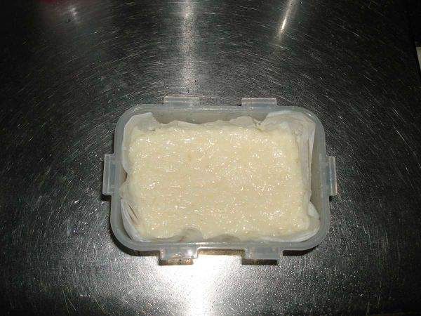 鋪上烘培紙，將奶凍餡倒入盒中，最後入冰箱冰至凝固即可....