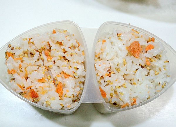 在將拌好的飯倒入三角飯糰模型中.壓成型後最後再底部包上海苔片就好.