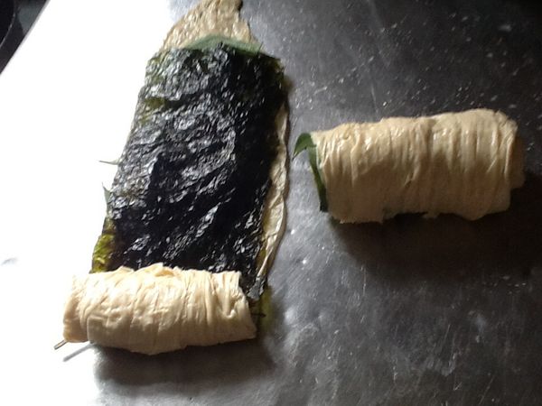 由ㄧ端往內捲，捲至尾端，成圓柱狀，收口面朝下放。