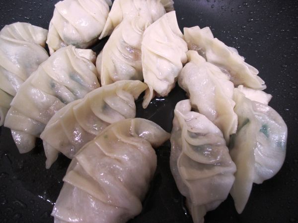 加少許水到鍋內，馬上蓋上鍋蓋，轉小火讓蒸氣把煎餃上部燜煎熟透。約需要3分鐘，太久會焦喔！(加水時要小心，可能會濺油。)