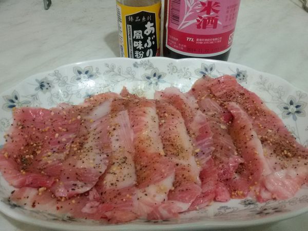 松阪豬切片，加入一小匙米酒抓一抓，再一片片攤開撒上和風碳烤粉，醃約15-20分鐘。