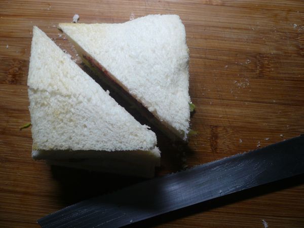 切用麵包刀將土司由中心對切成二塊三明治。