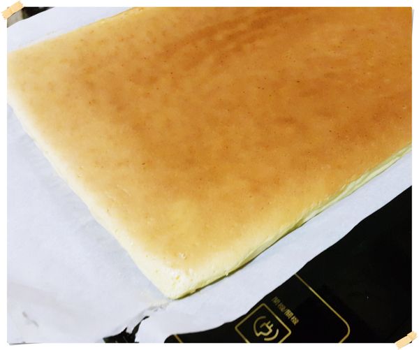 蛋糕一熟立即將蛋糕片連同烘焙紙拖出來.將烘焙紙四周揭開散熱