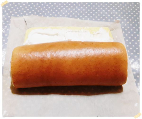 直接拉起烘焙紙邊捲邊輕壓.將蛋糕捲捲起