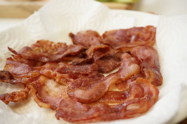 取廚房用紙巾將煎好的培根多餘油脂吸淨。