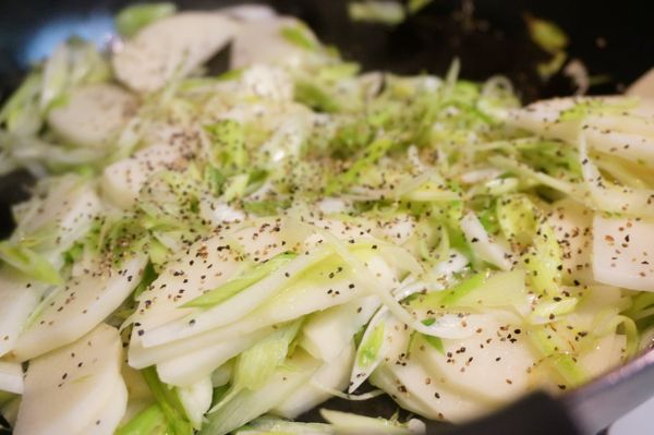 無鹽奶油熱鍋後將蒜苗絲(只取蒜白部分)及馬鈴薯片加上適量的黑胡椒炒香。