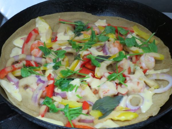 最後放起士絲和綠色葉菜(所有食材要灑均勻)。這個是放碗豆苗和少許的九層塔，直到起士絲融化即可。沒有起士絲的朋友，可以改成少許蛋液，這樣餡料就能與餅皮結合。記住，薄薄少少的蛋液灑均勻即可。