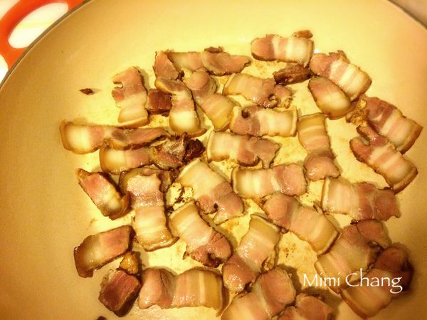 使用平底鍋，中火熱鍋後將鹹豬肉放入翻炒，炒至變色，油稍微熔出。